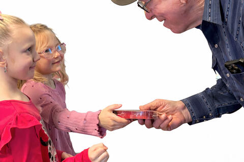 Kindergarten students were thrilled to make a trip to the Allen Nutrition Site last Friday to gift the diners with candy and entertain them with songs. Here James Arnold receives his Valentine candy from two lovely young ladies, Kinsley Gierodimos and Cheyenne McCarthy