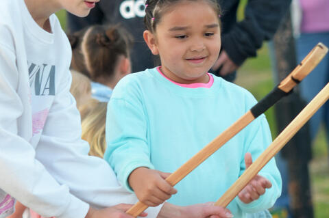 Tinsley Wofford helped Tehleah Smith on the Stickball stick egg race Saturday night