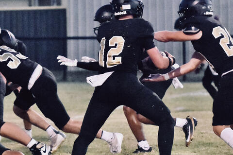 Noah Bray takes a handoff from quarterback Quintin Box