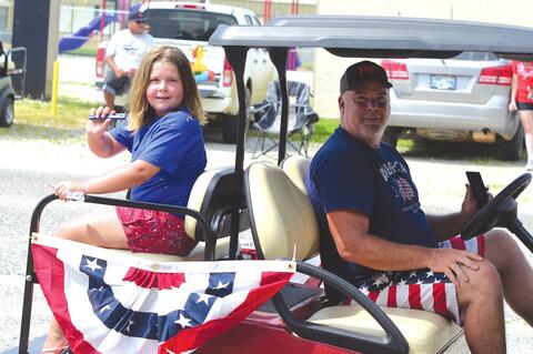 Kami and William showing off their neighbor Harold Akins golf cart.