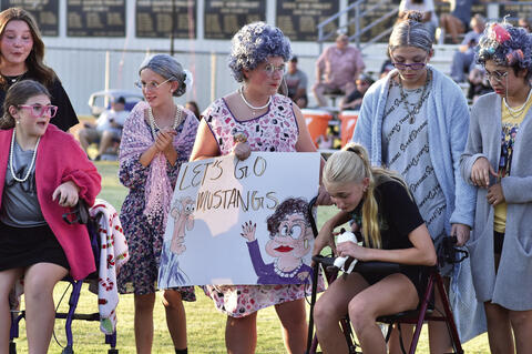Mustang Fans of ‘All’ Ages came out to cheer on the Mustangs at their opener last Firday nigh. These Junior High girls took the theme Senior Citizen night seriously.below Colt Bryen got a little sleepy but kept cheering on the team.