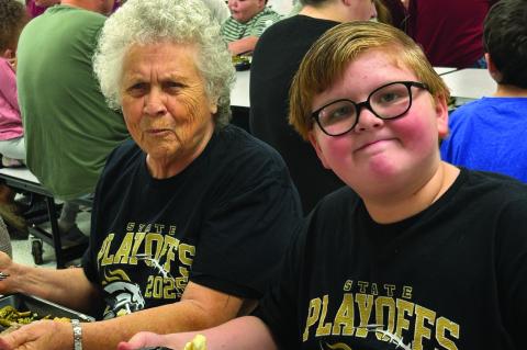 Ryker Whatley enjoyed eating with his best friend Linda Tatum. They were both ready for the football game in their matching shirts.